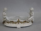 un bol blanc et doré orné de deux cherensils