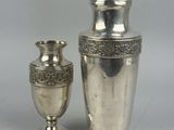 deux vases en argent posés l'un à côté de l'autre sur une table