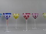 six different colored wine glasses are lined up in a row