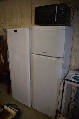 a white refrigerator and a microwave in a small room