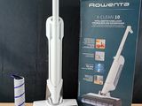 une boîte contenant un aspirateur posée sur une table, à côté d'une boîte de produits d'entretien
