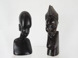 two sculptures of a man and a woman on a white surface