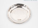 a silver plate on a white surface with a blue background