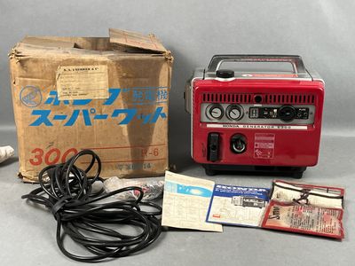 une photo d'un générateur portable rouge posé sur une caisse