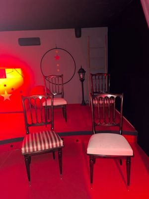 four chairs in a room with a red light in the background