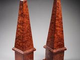 a pair of wooden obelis on stands on a grey background