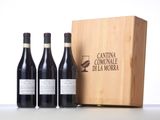 three bottles of red wine in front of a wooden box