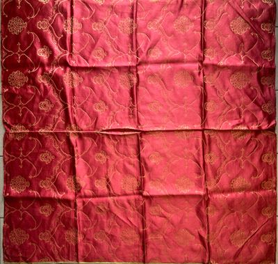 a close up of a red and gold quilt on a table