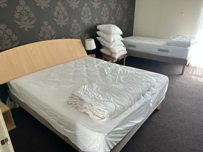 deux lits dans une chambre, avec un mur tapissé derrière eux