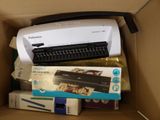 a box with a printer and several other items in it