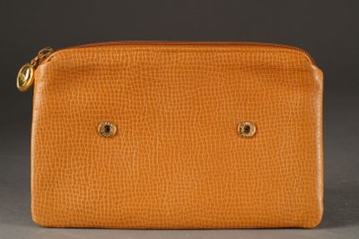 an orange leather purse with two small holes on the front