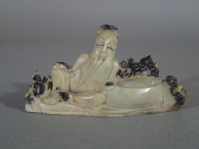 une figurine représentant un homme allongé sur une étendue d'eau
