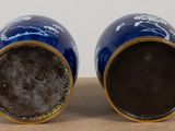 two blue vases sitting next to each other on a table
