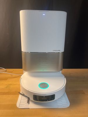 a close up of a white speaker on top of a wooden table