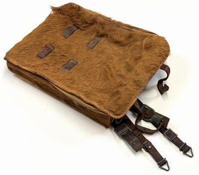 sac à dos en cuir et toile avec des sangles, sur fond blanc