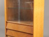 une vitrine en bois avec des portes vitrées et des tiroirs