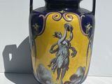 a blue and yellow vase with a painting on it