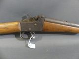 an old gun with a wooden handle on a gray surface