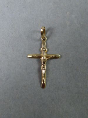 gros plan d'une croix en or sur une surface blanche
