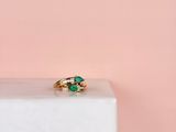 un gros plan d'une bague en or sertie d'une pierre verte