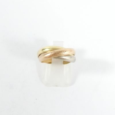 gros plan d'une bague en or et en argent sur une surface blanche