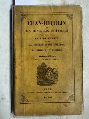 un vieux livre posé sur une table à côté d'un mur blanc