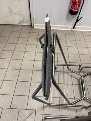 une paire de ciseaux posée sur un support métallique