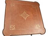 brown leather tray with a decorative design on top of it