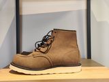 un gros plan sur une paire de bottes marron posées sur une étagère en bois