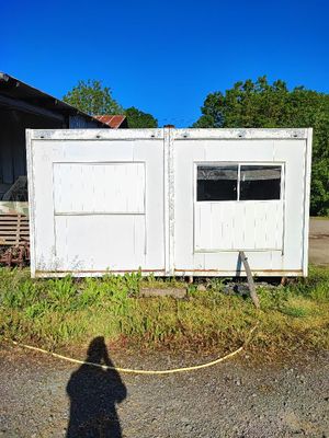 l'ombre d'une personne debout devant un bâtiment blanc