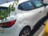 a white car parked in a parking lot next to a yellow car