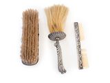 a brush, comb, and comb on a white surface