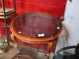 une table avec un plateau en verre et une chaise placée devant un mur rouge