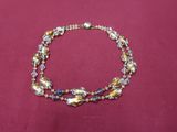 bracelet composé de perles de verre multicolores montées sur un cordon en tissu rouge