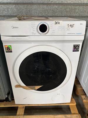 une machine à laver blanche posée sur une palette dans une pièce