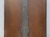 une plaque en bois ornée d'un motif métallique