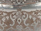an antique silver plate with a floral design on it