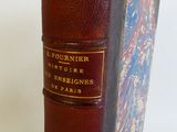 un vieux livre à la couverture en cuir marron posé sur une table blanche