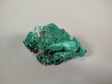 some green crystals on a white surface with a white background