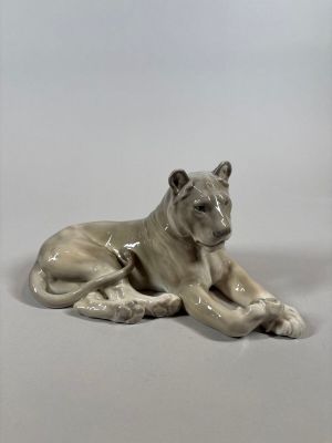 a porcelain figurine of a dog laying down on the ground