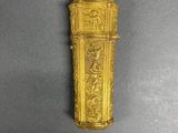 an antique gold plated clock on a gray surface with a black background