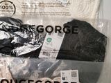 three pairs of women ' s sweaters are wrapped in plastic bags