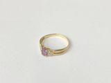 a close up of a gold ring with a pink stone on it