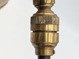 a close up of a brass pipe with a hose attached to it