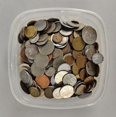 un récipient en plastique rempli de pièces de monnaie posé sur une table