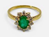 gros plan d'une bague en or avec une pierre verte