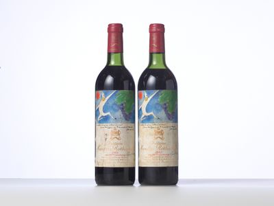 two bottles of red wine sitting on top of a table