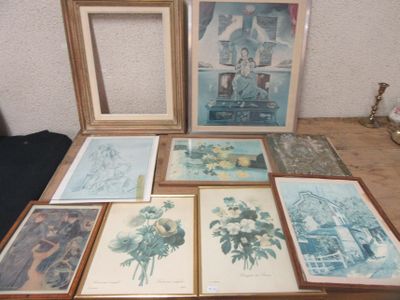 many framed pictures on a table with a vase of flowers
