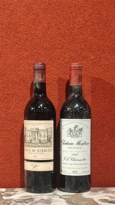 deux bouteilles de vin posées sur une table près d'un mur orange