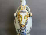 un vase sur lequel est peinte une tête de chèvre